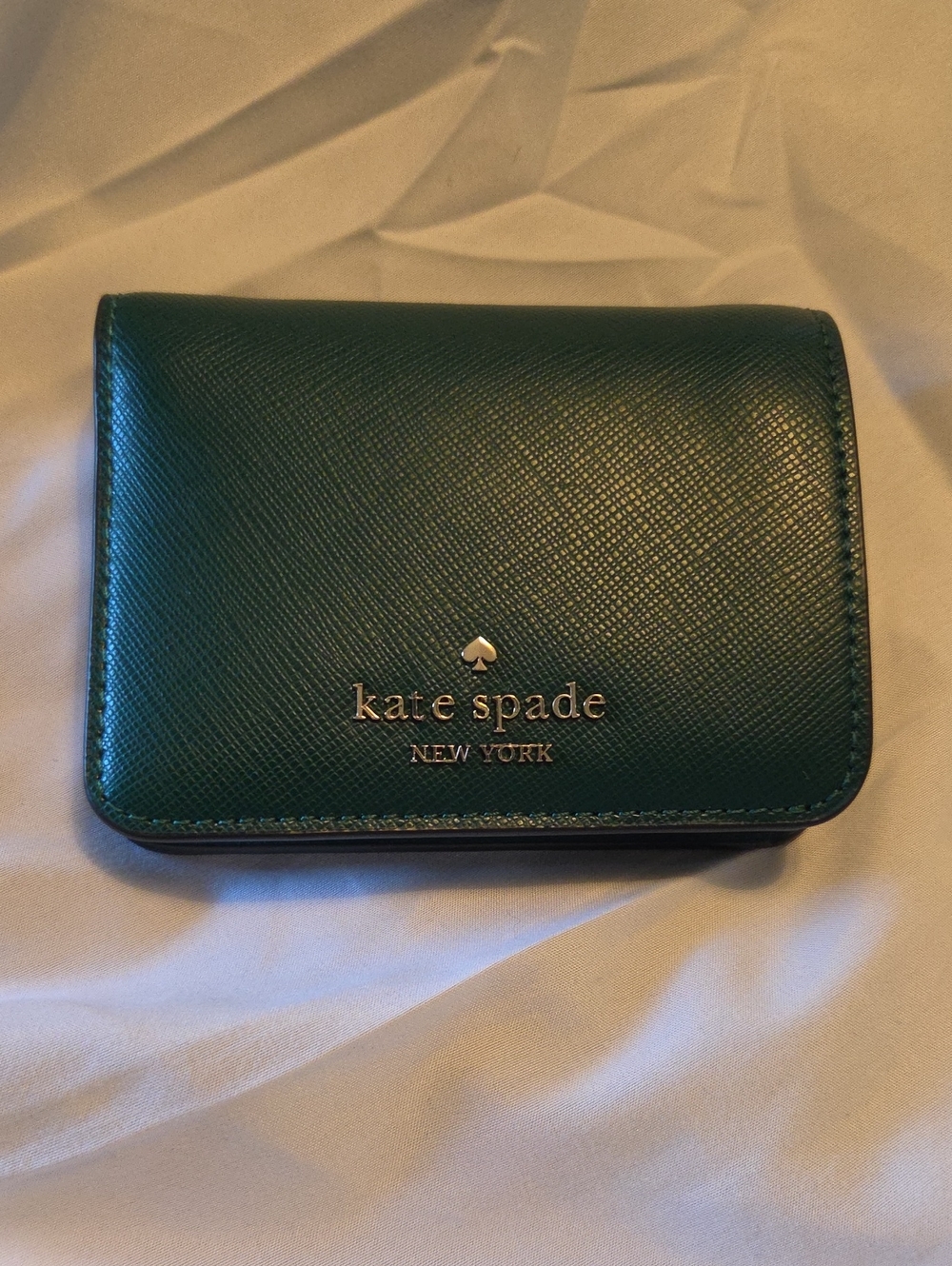 kate spade New York dark green saffiano bi-fold wallet with gold logo